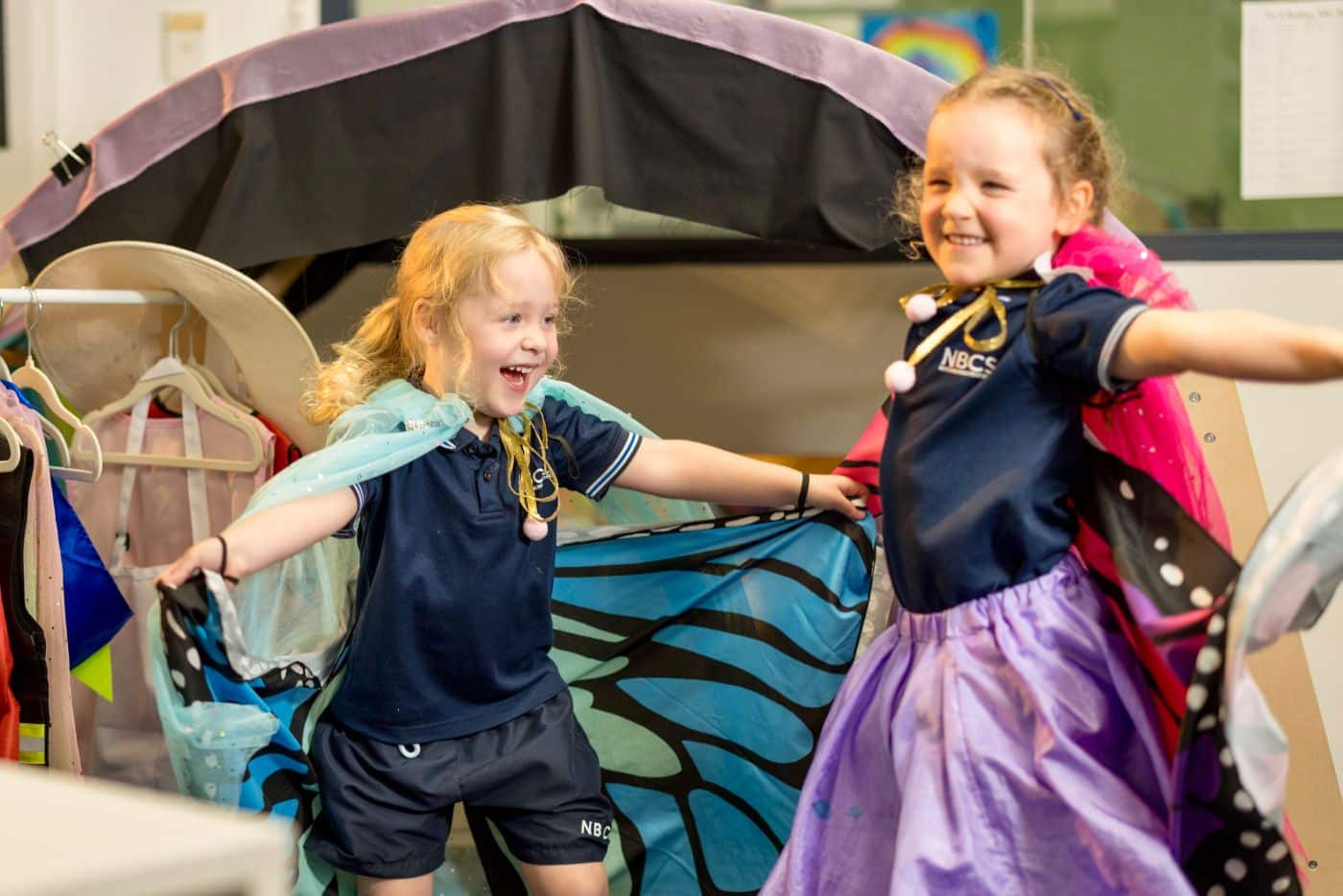 successful school readiness program at Northern Beaches Christian School. Two little girls dancing in dress up clothes in the Pre-K classroom at Northern Beaches Christian School